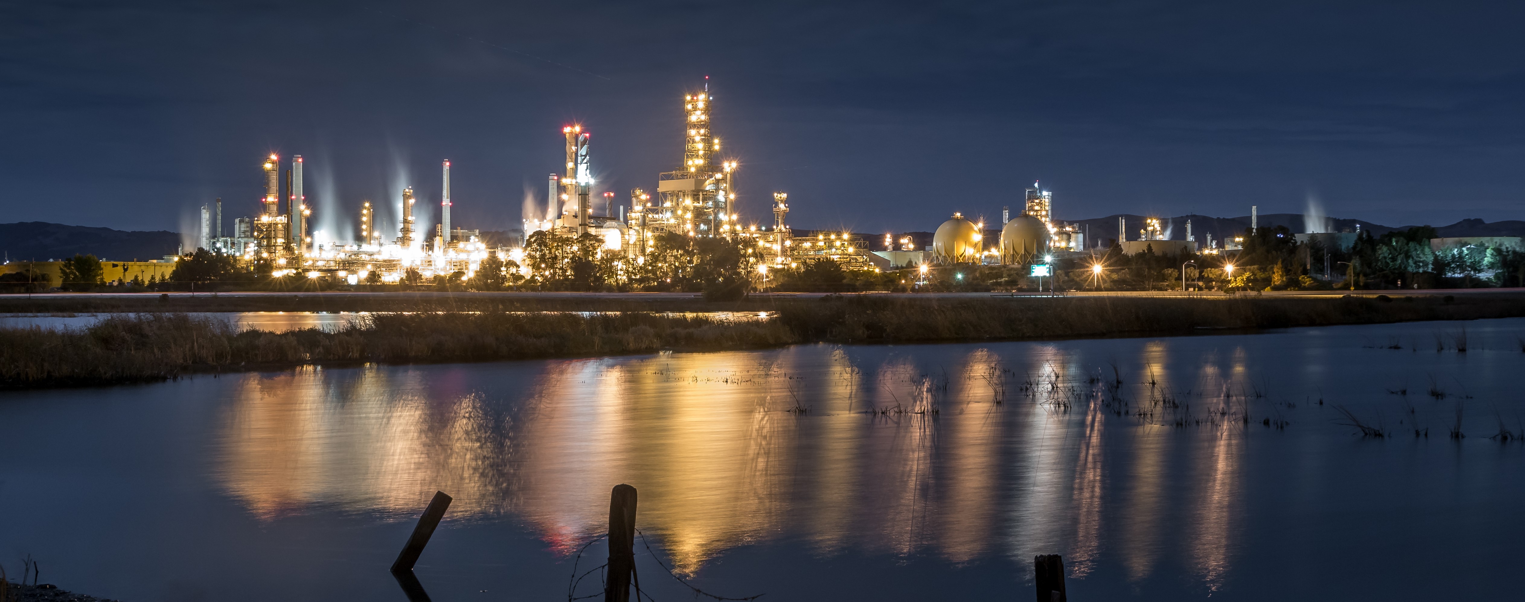 Martinez refinery lit up at night over the Bay.