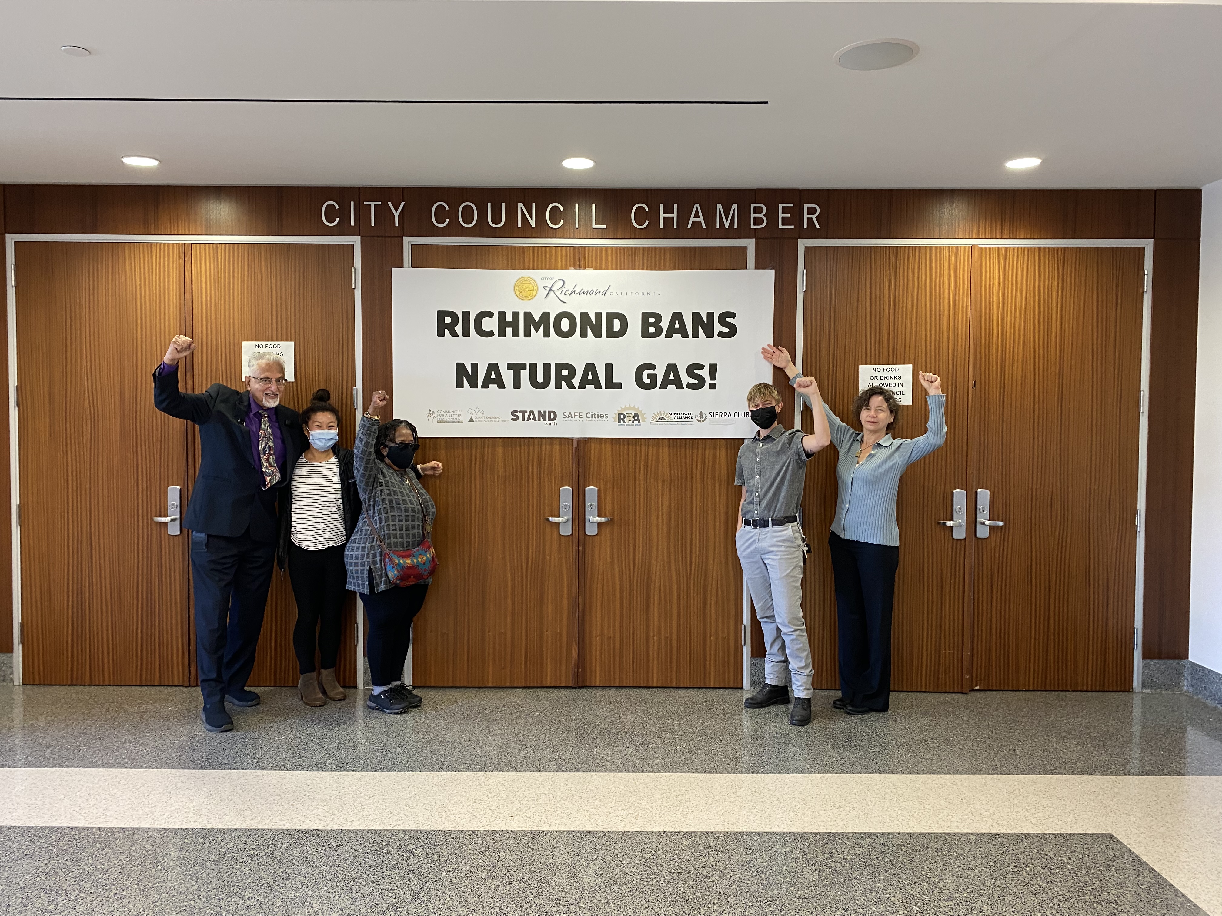 Richmond City Councilmembers and Melissa Yu celebrating the win with a banner saying Richmond Bans Natural Gas