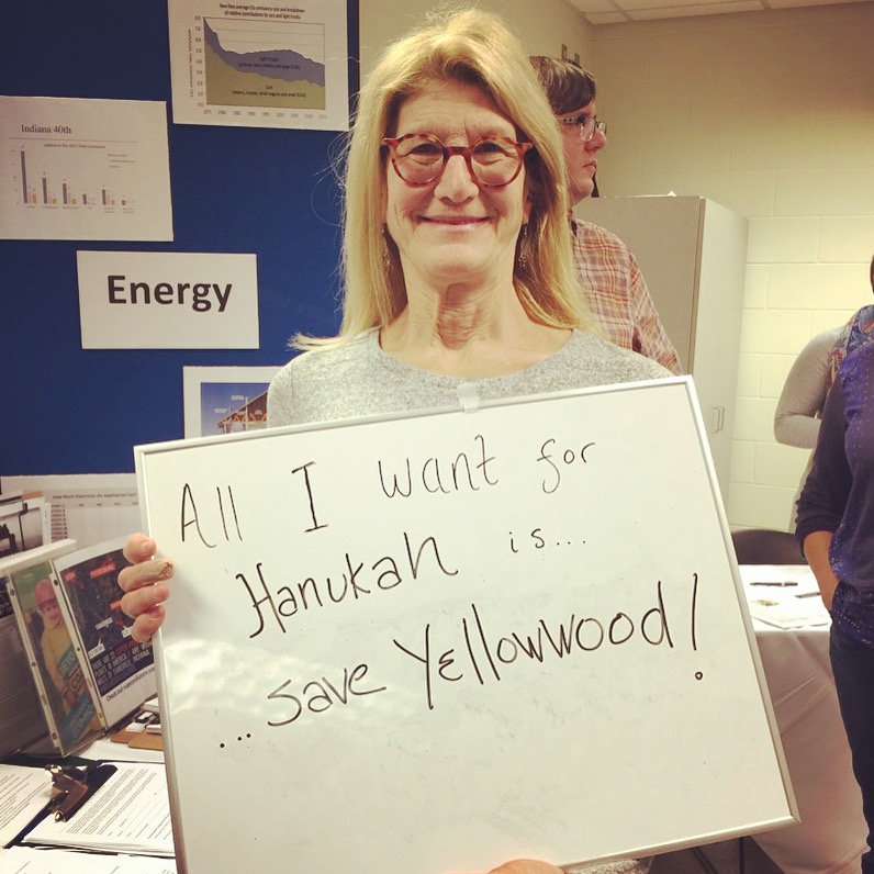 Lori at HEC with a sign saying "all I want for Hanukah is Save Yellowwood!"