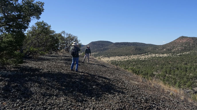 People standing in front of Chain of Craters Road sign