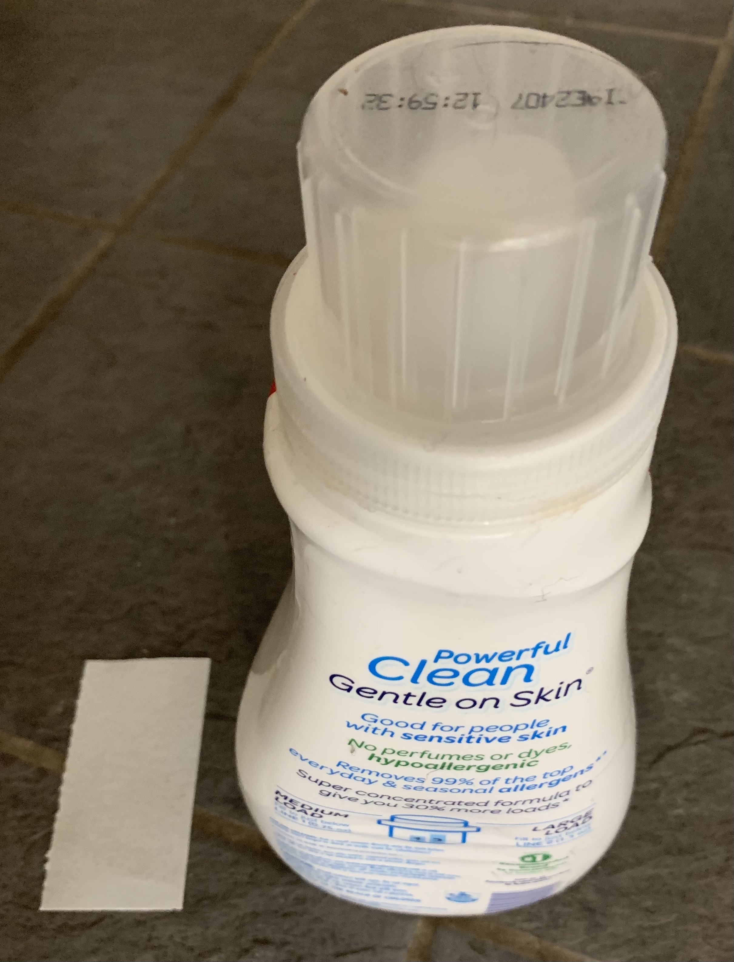 A bottle of laundry soap in a plastic container