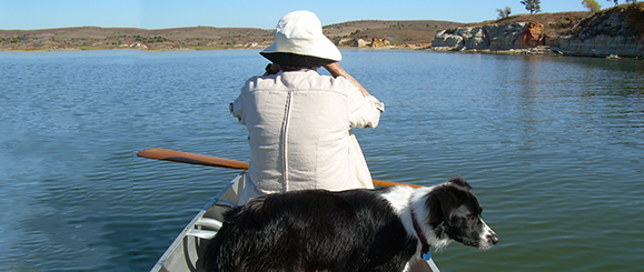 woman hat and black and white dog in boat