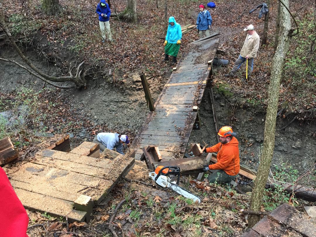people rebuilding a bridge on trail
