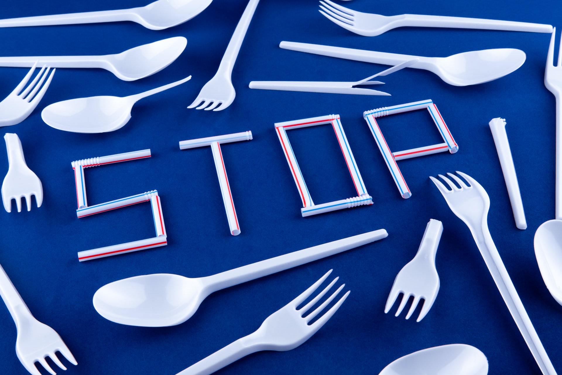 white plastic items arranged on blue background to spell STOP