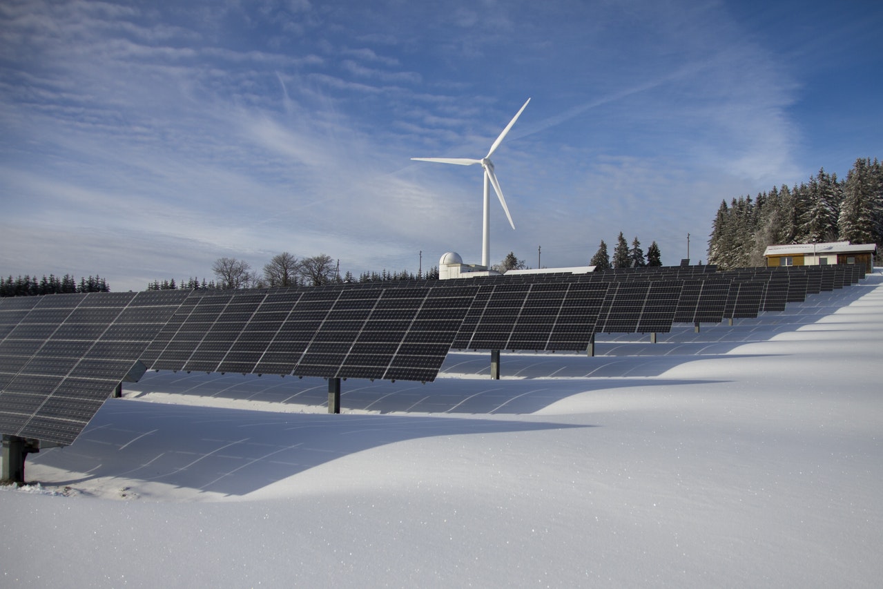 solar panels in snow with wind turbine