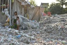 Children in Indonesia amid a field of plastic waste, all imported from the US, EU, and other Western nations.