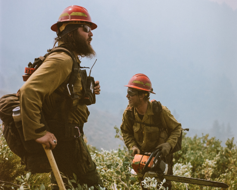 two men in hardhats outside to fight fires