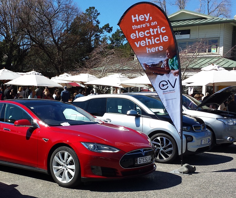 An electric vehicle is shown on display in a parking lot