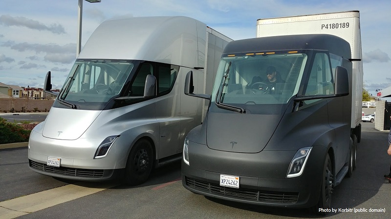 Two electric emi trucks are shown parked side by side