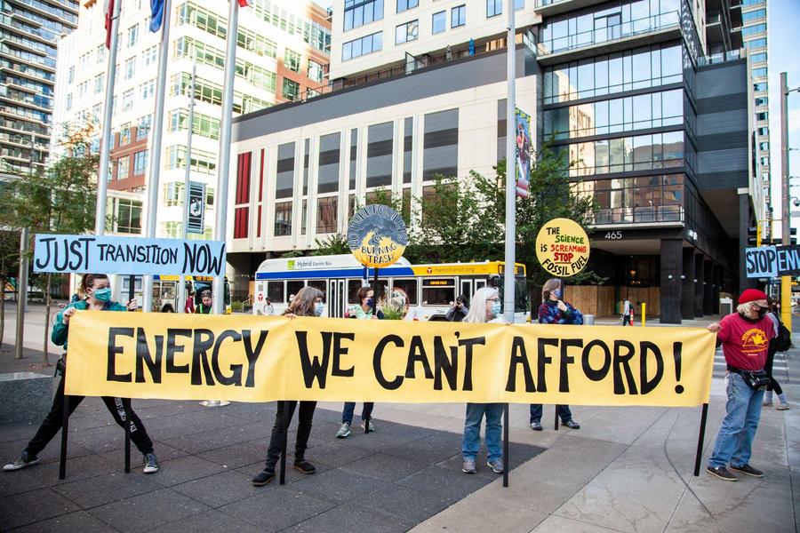 photo of demonstrators holding sign saying, "Energy We Can't Afford!"