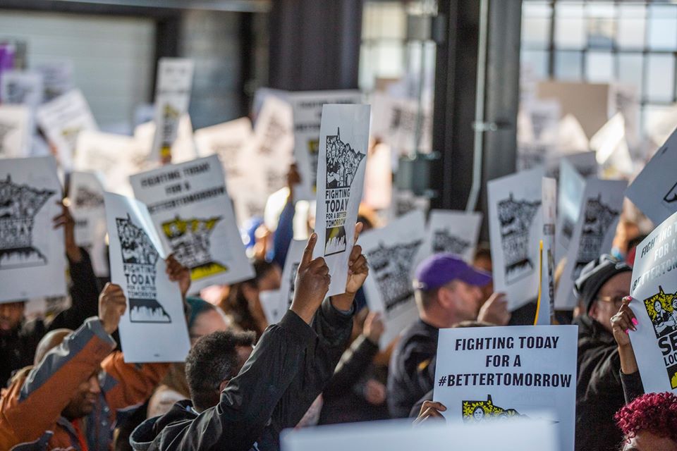 photo of workers rallying, holding signs saying, "Fighting Today for a Better Tomorrow"