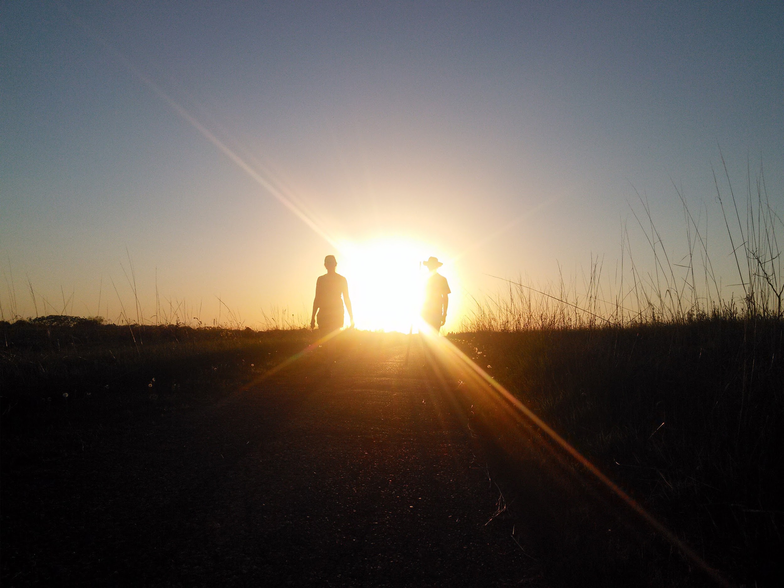 photo of two people silhoutted by the sun