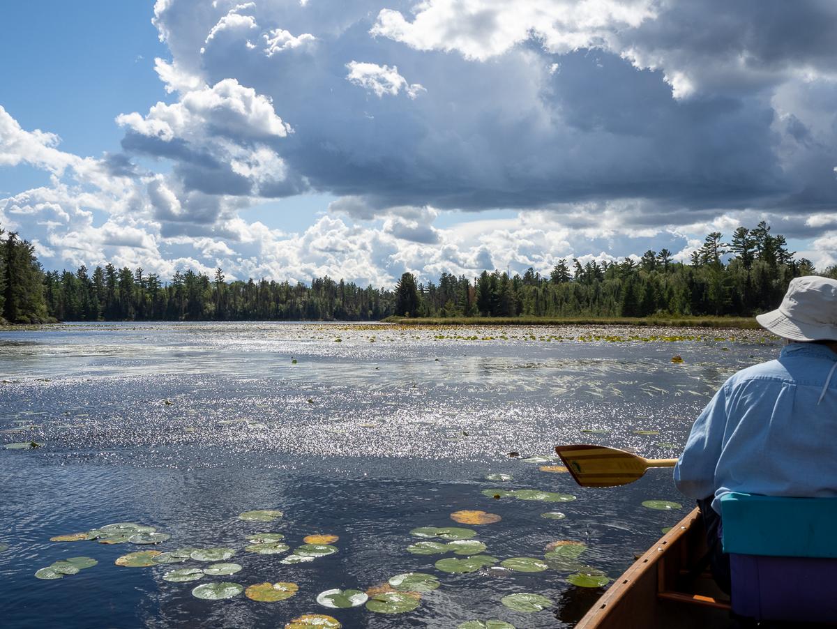 photo of canoer on a Minnesota lake on bright, sunny day