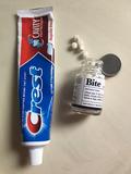 photo of toothpaste in a plastic tube next to toothpaste tablets in a glass jar