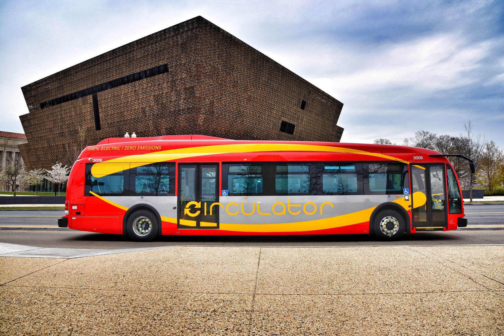 Red, yellow, and grey electric bus with the word "circulator" on the side parked in Washington, D.C.