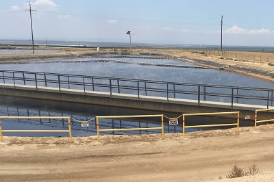 Steaming "produced water" pit with farmlands in the background