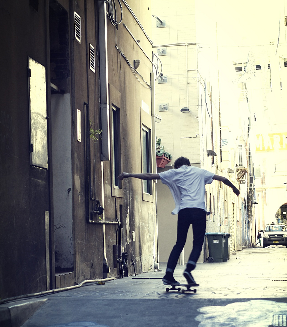 Silhouette of skateboarder in an urban alley