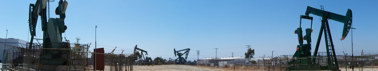 Several working oil pumps under a blue sky