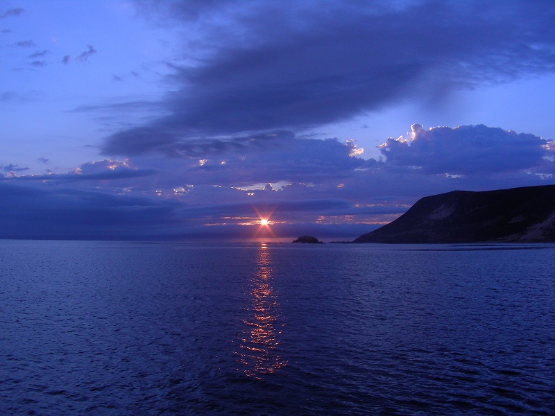 Late sunset over ocean and island cliffs