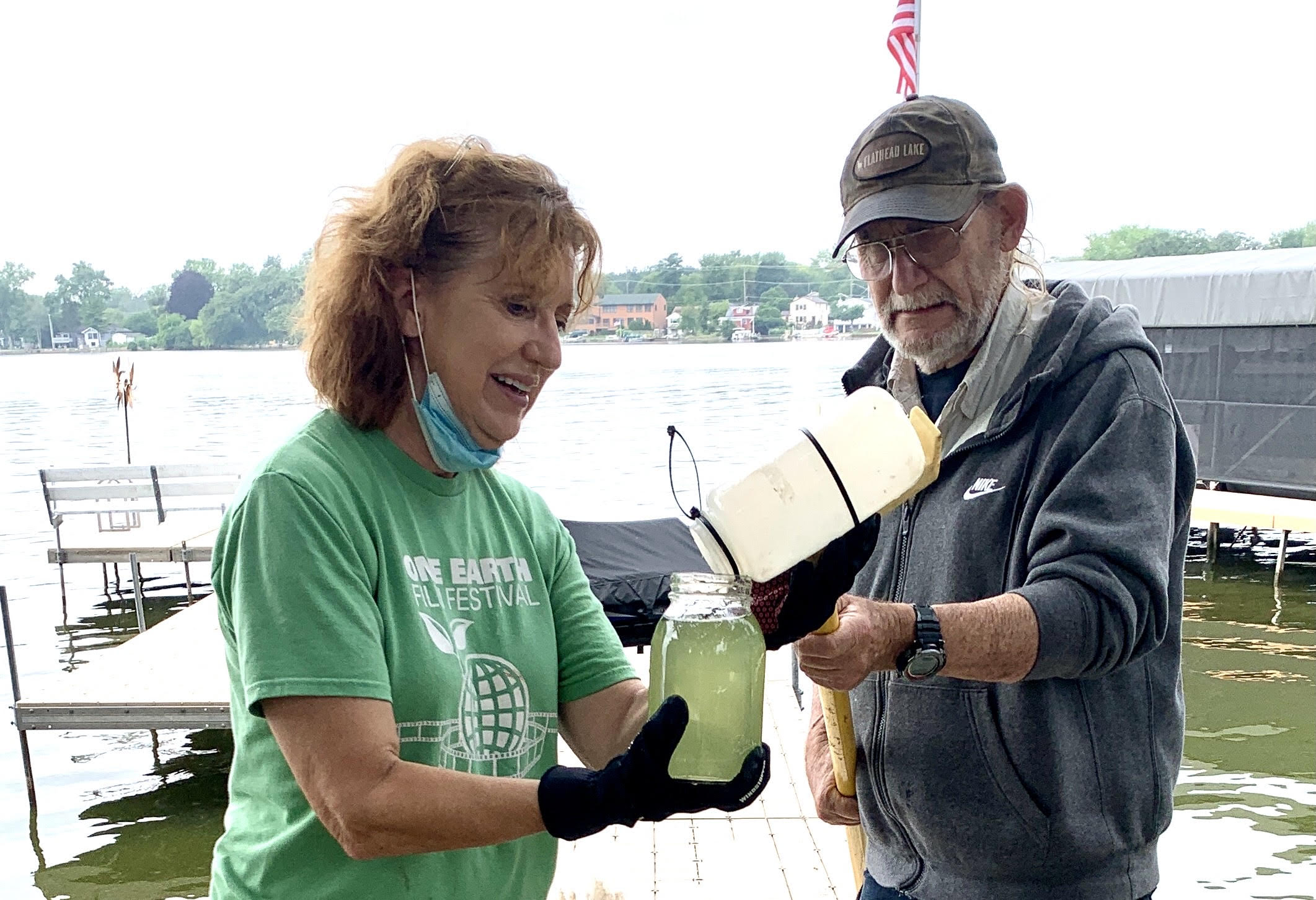 Gloria Charland and Jim Bland take a sample of cyanobacteria from a lake in western Lake County.