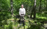 Bird Logan, a citizen of the Tonawanda Seneca Nation, standing in the middle of the Big Woods. 