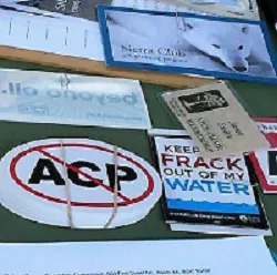 A close-up of stickers and handouts on a table at a protest against the Atlantic Coast Pipeline