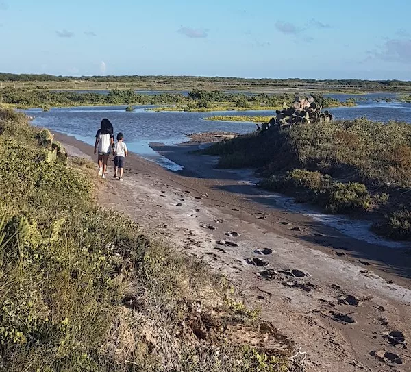 kids walking on marshy coastal area where Rio Grande LNG is planned to be built