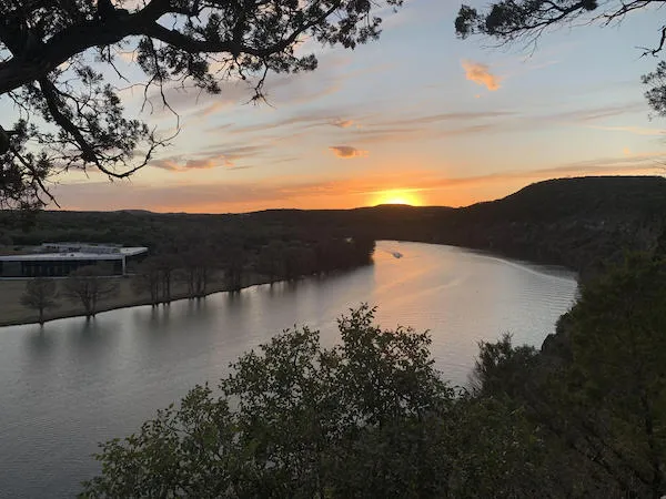 The sun sets over a river.