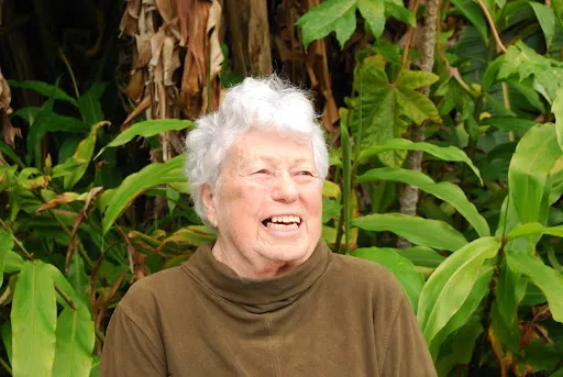 Becky Evans smiles on a natural green and brown background