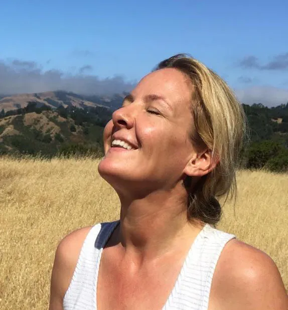 Wietske Medema smiles up to the sky on a gold grassy background