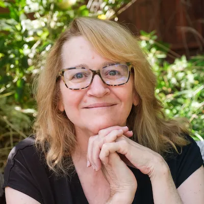 Martha Kreeger smiles on a green natural background