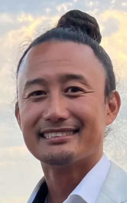 Brian Reyes smiles in an up-close headshot