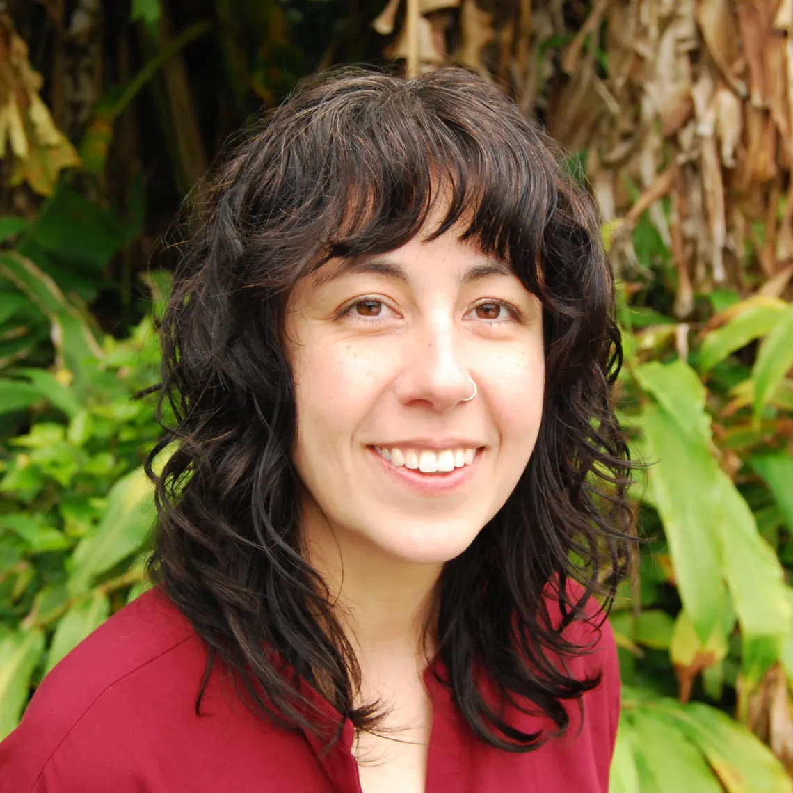 Kelly Akemi Groth smiles on a natural green background