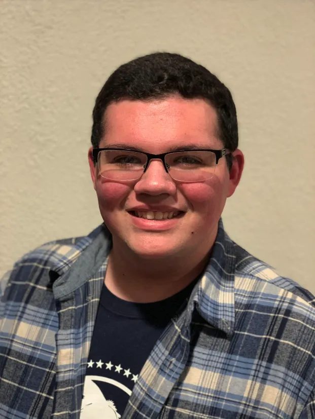 Joseph Mauro smiles against a cream background