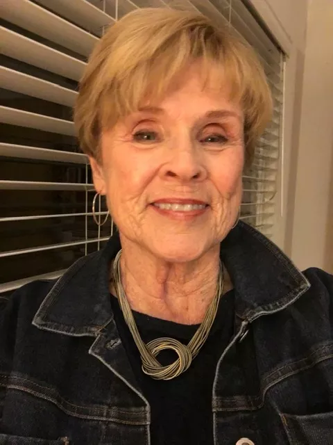 Linda Milanese smiles in an indoor setting