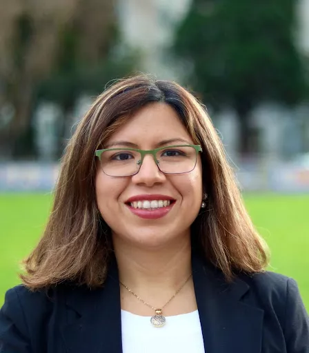 Ana Vasudeo smiles on a green background