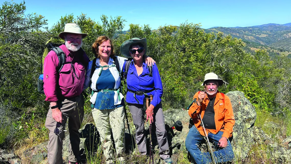Ralph Alcorn, Susan Alcorn, Patricia Schaffarczyk, Tom Coroneos stand atop a peak. Photo by David Sanger Photography.