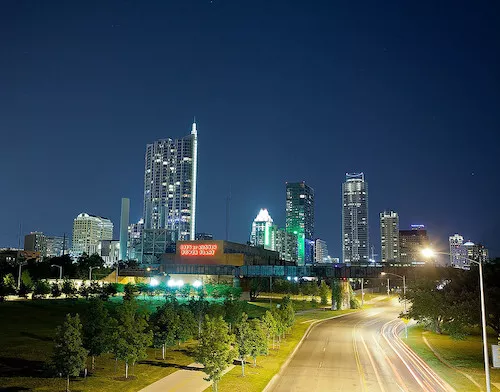 Austin skyline at night with City of Austin power plant in forefront.