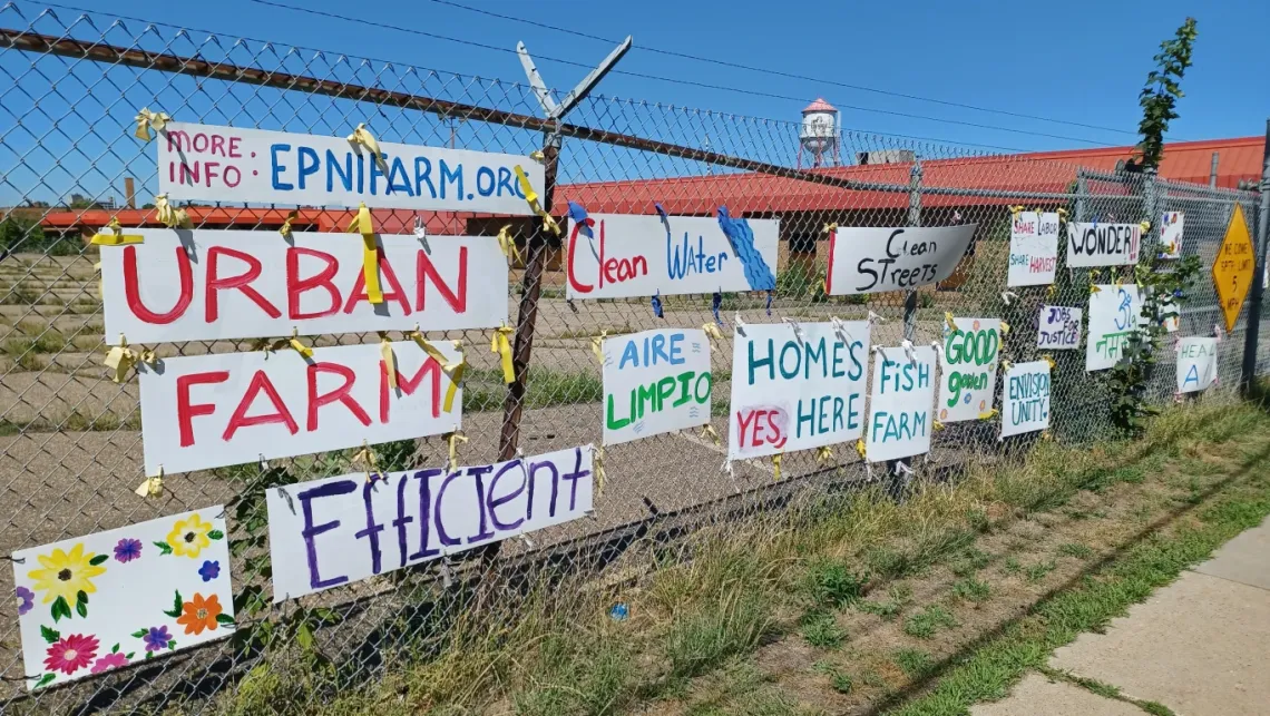 Fenceline outside of Roof Depot site, "Urban Farm" banners on fence in support.
