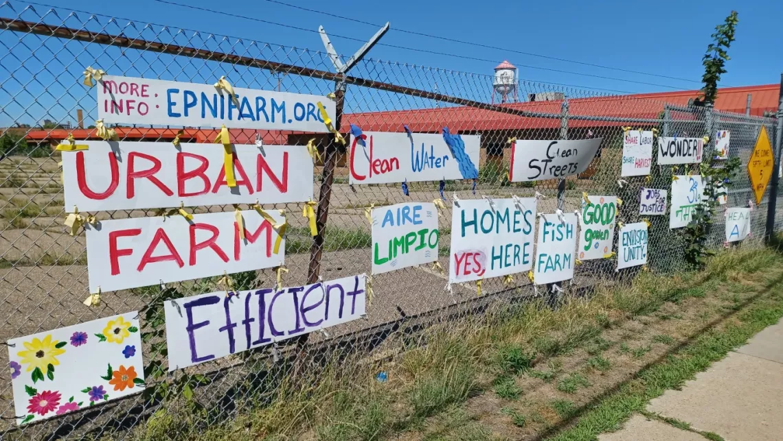 Fenceline outside of Roof Depot site, "Urban Farm" banners on fence in support.