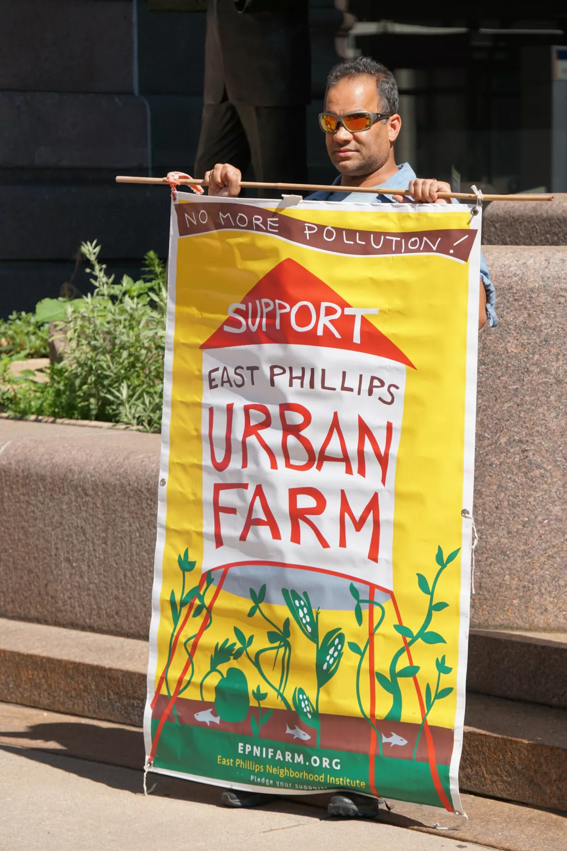 Satish Desai, the author, hold a sign at a press conference outside City Hall. Photo credit: MCEA/Adam Reinhardt
