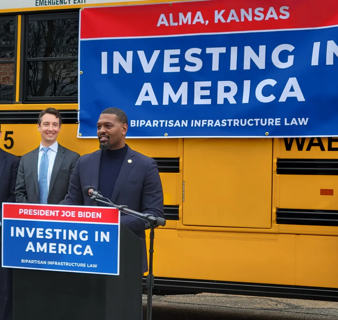 white man and black man in front of yellow electric bus in Alma KS