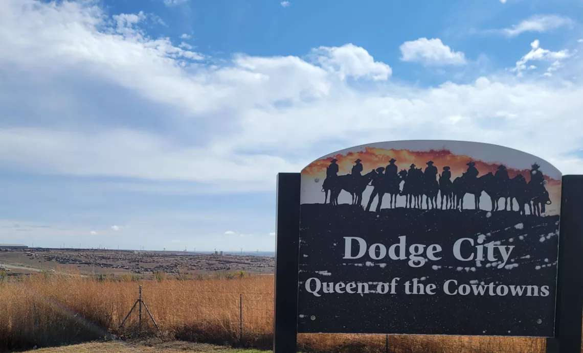 Dodge City, KS scenic overlook sign, blue skies and amber grasses overlooking vast cattle feedlkots