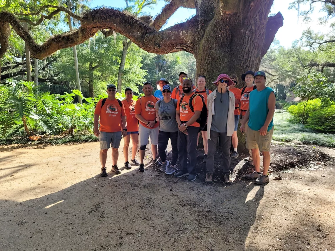 A group of veterans poses by a tree in Washington Oaks Gardens State Park in Florida.