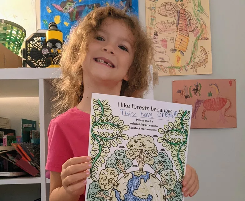 Photo of Juni with her coloring page to protect our forests