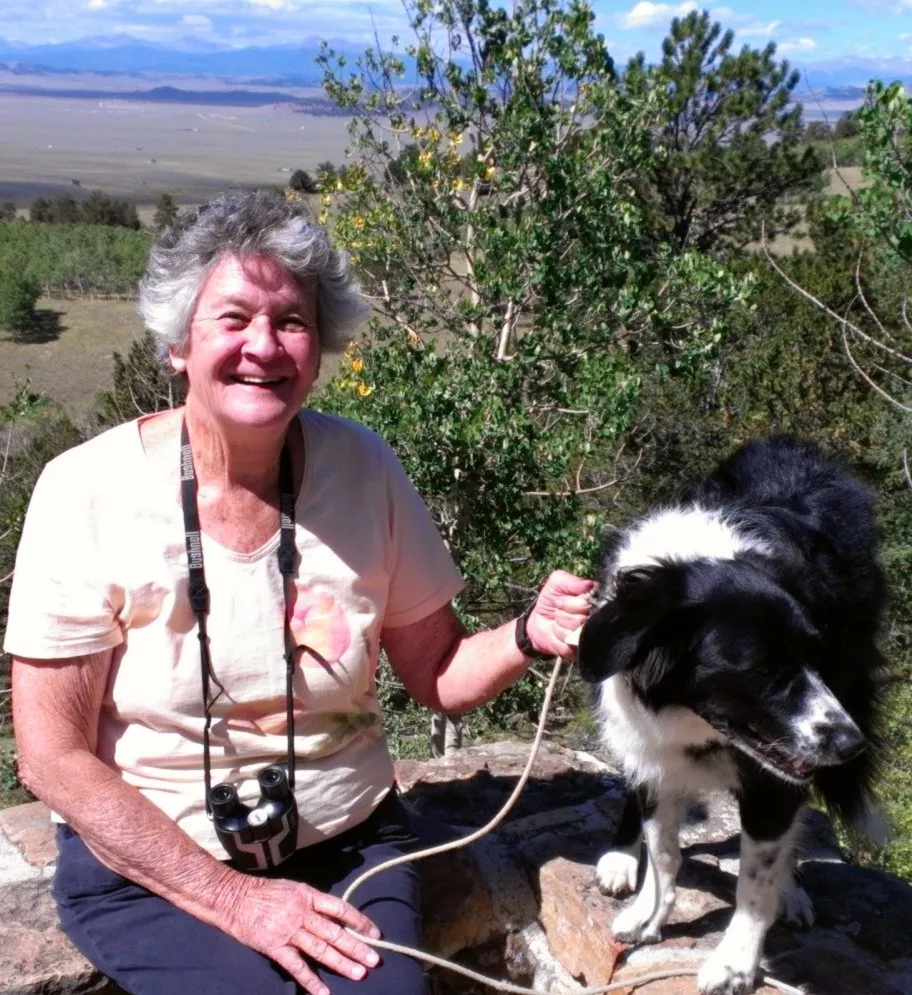woman with camera and black and white dog 