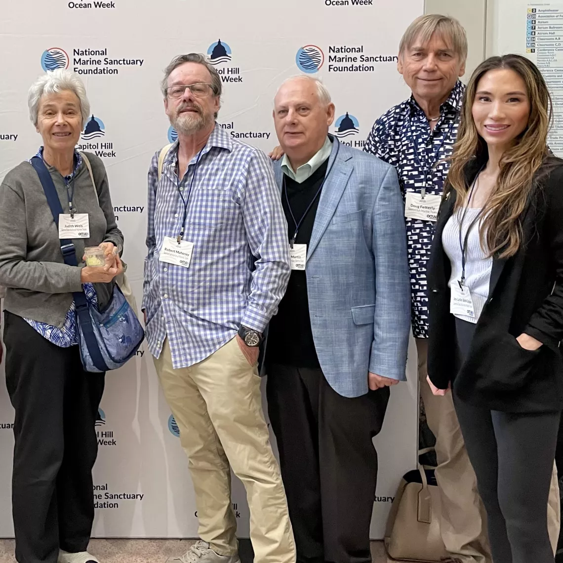 Five members of the marine team stand together wearing badges. 
