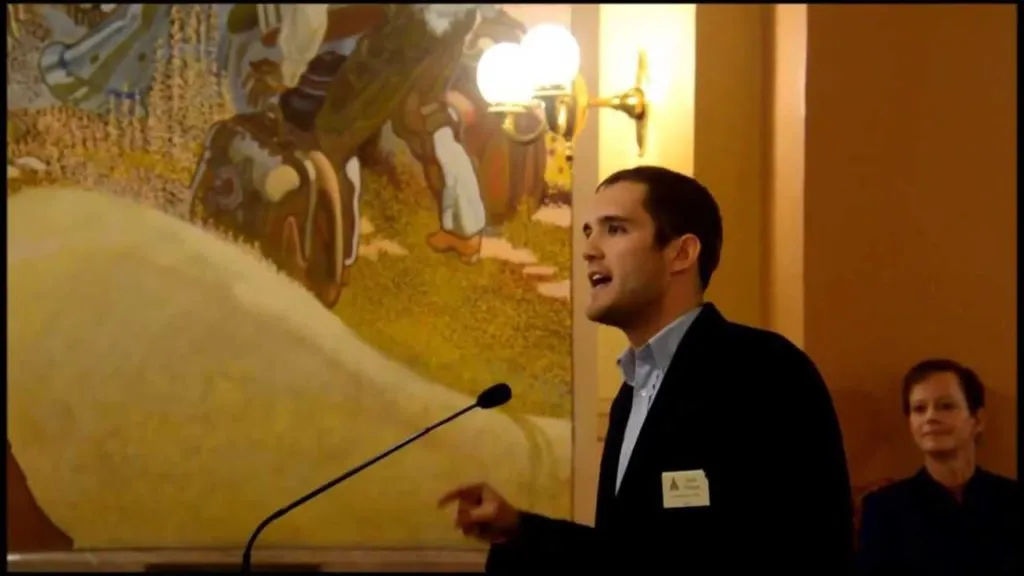 man in front of microphone in Kansas capitol