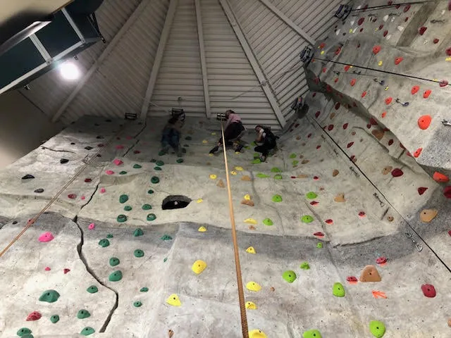 Three people climbing on a rock wall