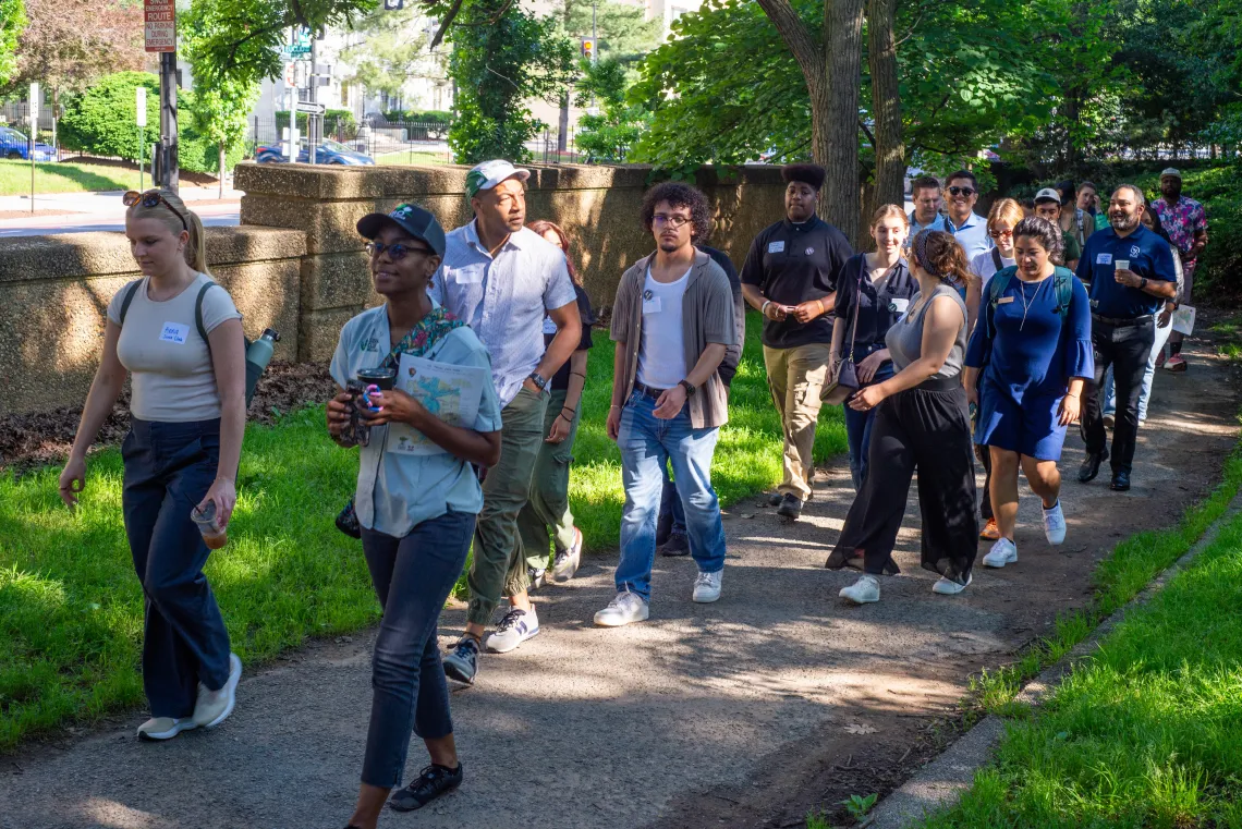 A group of people walk down a path in a park